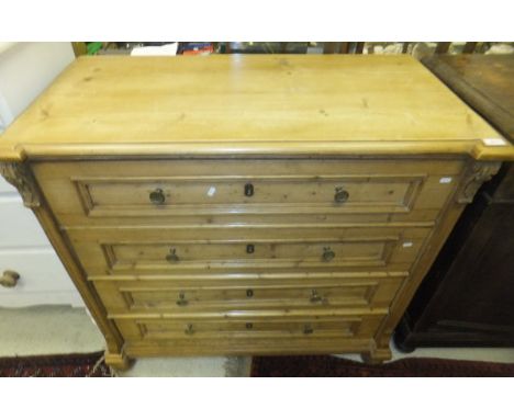 A 19th Century pine commode, the plain top above four panelled drawers with brass handles raised on bun feet