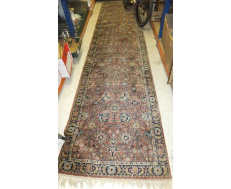 A Persian pattern Wilton runner, the all-over floral and foliate decoration in duck egg blue, cream and mustard, on a salmon 