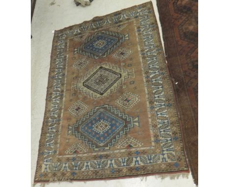 A Caucasian rug, the central panel set with lozenge shaped medallion on a pale pink ground set with hook motif decorated meda