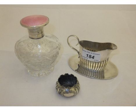 A George V silver topped cut glass scent bottle with engine turned and enamel decorated lid (Birmingham, 1929), together with