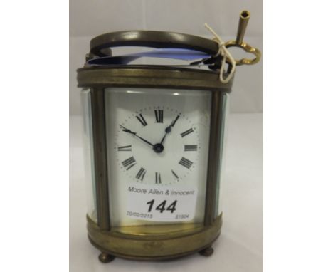 A brass carriage clock with Roman numerals to the dial 