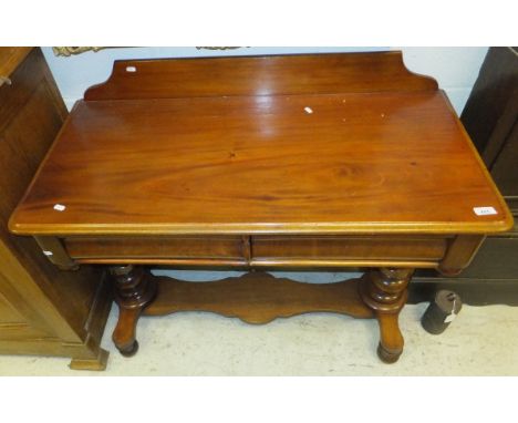 A Victorian mahogany side table with two cushion drawers, raised on turned and ringed baluster supports united by a shaped po