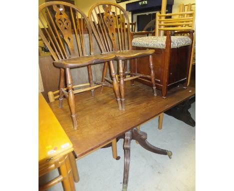 A mahogany tilt-top single pedestal dining table in the Regency taste on brass caps and castors, the top originally a section