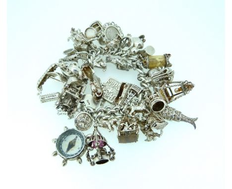 A silver Charm Bracelet, the bracelet with oval links and silver padlock clasp, hung with many silver charms including, compa