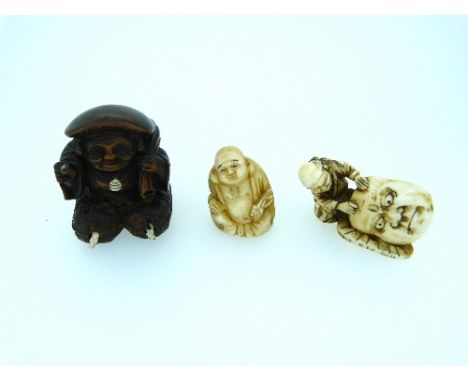 A 19thC Japanese ivory Netsuke, of a man holding a mask, 1¾in (4.5cm) wide, and another Japanese ivory figural netsuke, toget