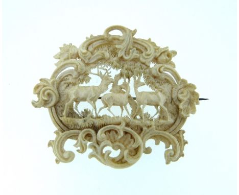 An attractive ivory plaque Brooch, pierced and carved, the centre with woodland scene with a stag and two hinds, the surround