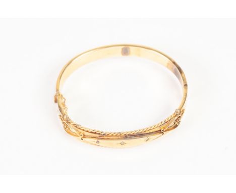 EDWARDIAN 9ct GOLD HOLLOW BANGLE, hinge opening, the top with raised lozenge shaped panel star set with three tiny diamonds, 