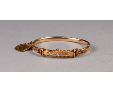 VICTORIAN 15ct GOLD HOLLOW HINGE OPENING BANGLE, the fancy filigree decorative top set with a row of thirteen small diamonds,