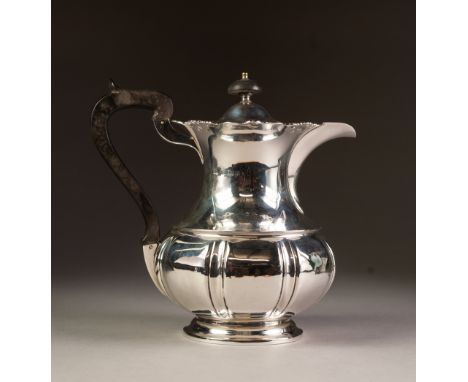 EARLY 20th CENTURY SILVER COFFEE POT of baluster shape with pierced scrolliated rim, blackwood handle and finial, on a circul