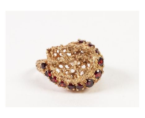 9ct GOLD PIERCED NUGGET PATTERN COCKTAIL RING, set with a curved row of twelve small rubies, 6.5gms, London 1981 