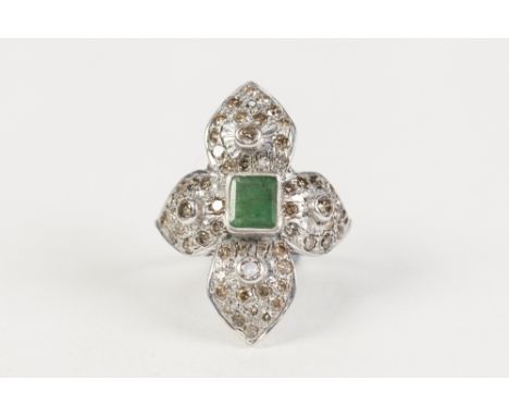 WHITE GOLD COLOURED METAL RING (unmarked) with centre collet set oblong emerald, the surround of four large petal forms, each