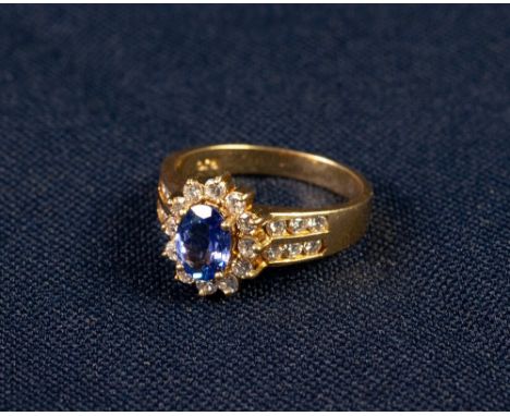 18ct GOLD TANZANITE AND DIAMOND CLUSTER RING, set with an oval tantanzite of medium deep bluish purple colour of type 1 clari
