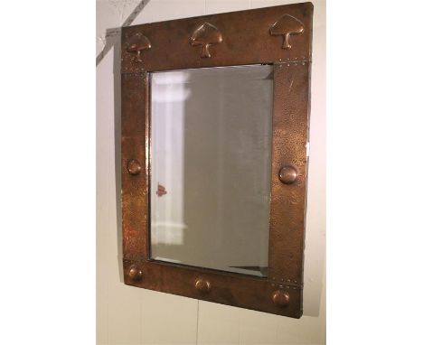 An early 20th cent Arts and Crafts copper mirror, attributed to LIBERTY with stylised repousse trees, with bevelled original 