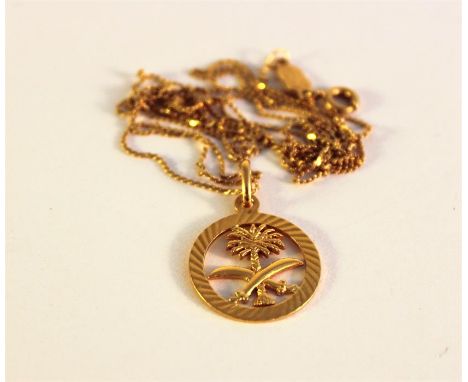 A 21k yellow gold Saudi Arabian circular openwork pendant cast with open palm tree and pair of knives to the centre on fine 1