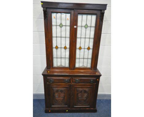 AN EARLY 20TH CENTURY MAHOGANY BOOKCASE, the upper section with double lead glazed/stained glass doors, above a base with two