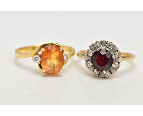 TWO YELLOW METAL GEM SET RINGS, the first of a cluster design, set with a central circular cut garnet, within a surround of s