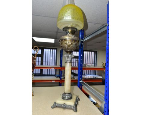 A LARGE ONYX, BRASS AND BRONZED SPELTER OIL LAMP, with chimney and a yellow, floral patterned glass shade,  brass reservoir e