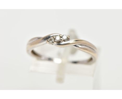 A 9CT WHITE GOLD DIAMOND RING, of a cross over design, centring on three claw set round brilliant cut diamonds, estimated tot
