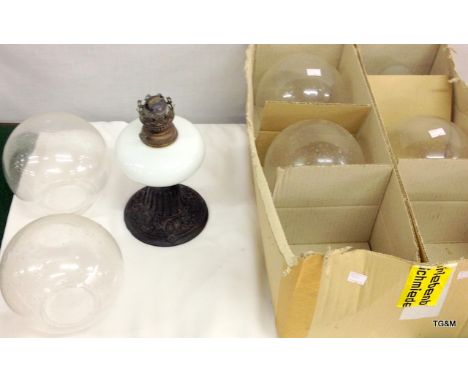 A small wrought iron lamp  and glass lamp globes