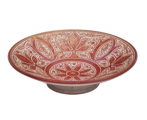 An art pottery shallow dish: of circular footed form with profuse ruby lustre decoration, central flowerhead surrounded by fl