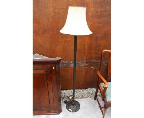 A BRASS STANDARD LAMP ON KNURLED COLUMN AND FOLIATE BASE COMPLETE WITH SHADE 