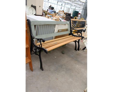 A WOODEN SLATTED GARDEN BENCH WITH DECORATIVE CAST BENCH ENDS 