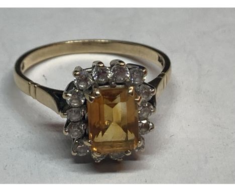 A 9 CARAT GOLD RING WITH A CENTRE CITRINE SURROUNDED BY CUBIC ZIRCONIAS SIZE R 