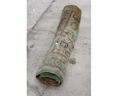 A VINTAGE GREEN PATTERNED FRINGED RUG 
