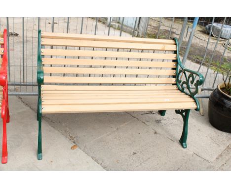 A WOODEN SLATTED GARDEN BENCH WITH DECORATIVE CAST ENDS 