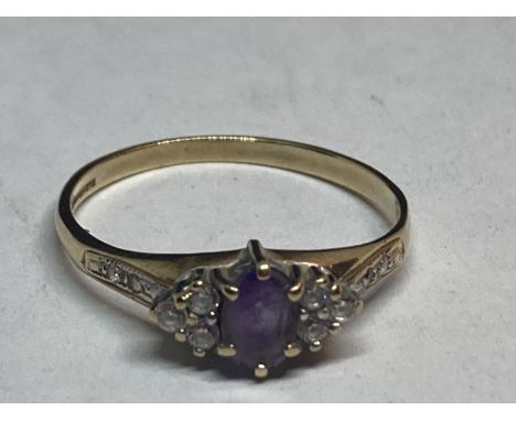 A 9 CARAT GOLD RING WITH A CENTRE AMETHYST SURROUNDED BY CUBIC ZIRCONIAS SIZE Q/R 