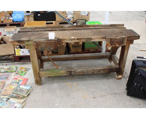 A VINTAGE WOODEN WORK BENCH WITH TWO VICES 