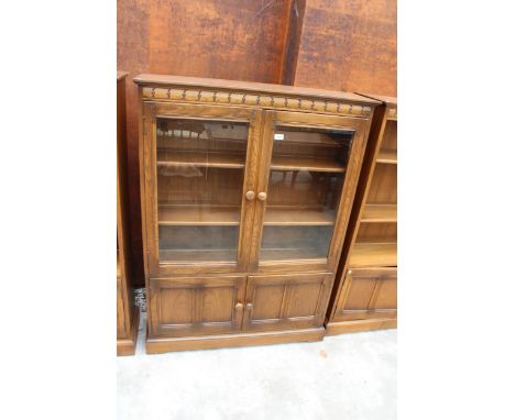 AN ERCOL BLONDE TWO DOOR BOOKCASE WITH CUPBOARD TO BASE 39.5" WIDE 