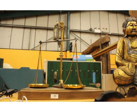 A SET OF BRASS BALANCE SCALES ON A WOODEN BASE 