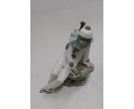 A NAO FIGURINE OF A CLOWN ON A ROCK 