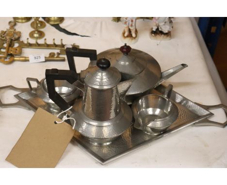 A VINTAGE HAMMERED PEWTER TEASET TO INCLUDE A TRAY, TEAPOT, HOT WATER JUG, CREAM JUG AND SUGAR BOWL 