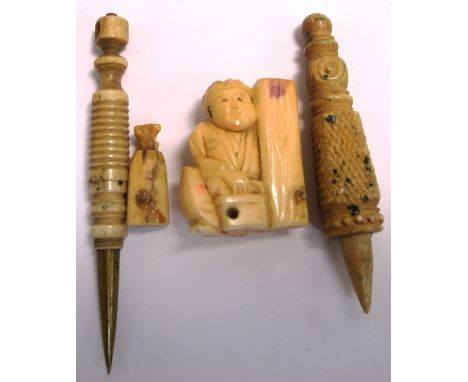 A small 20th century ivory netsuke and two turned sewing accessories (3).
