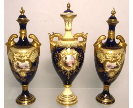 Coalport; a trio of late 19th early 20th century cobalt blue ground and gilt heightened baluster vases with scenic vignettes 