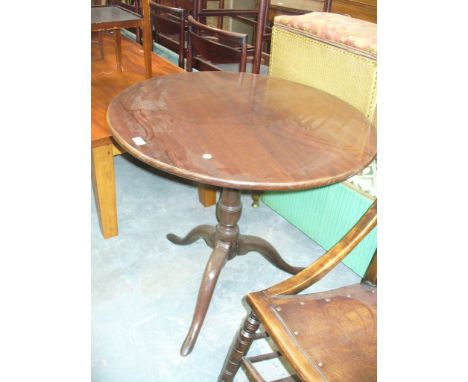 A Georgian mahogany tripod table , with a circular top on a bird cage mechanism, baluster ring turned shaft and three downswe