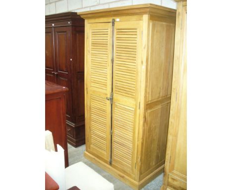 A Light oak French style wardrobe with two louvre doors raised on a plinth base.