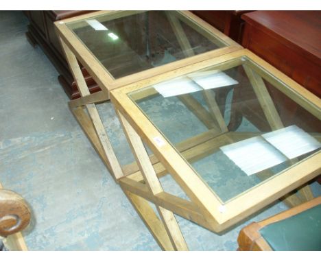 A Pair of contemporary light oak framed glass top tables raised on " X " framed supports.
