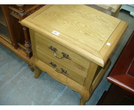 A Light oak French style two drawer bedside chest.