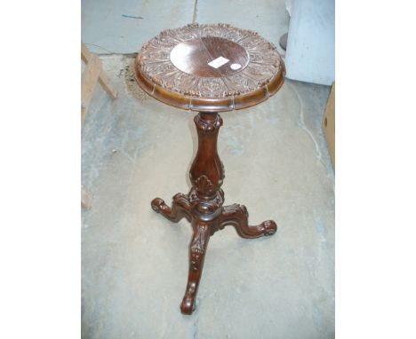 A Walnut tripod table the circular top with a leaf carved frieze, raised upon a baluster column with 3 down swept supports an