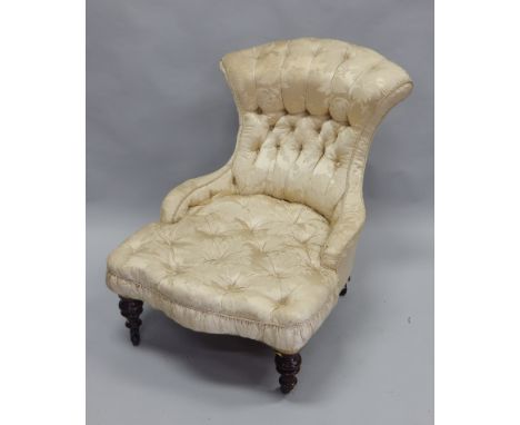 A Victorian mahogany nursing chair, elaborately upholstered in gold coloured floral damask, on turned legs with ceramic casto