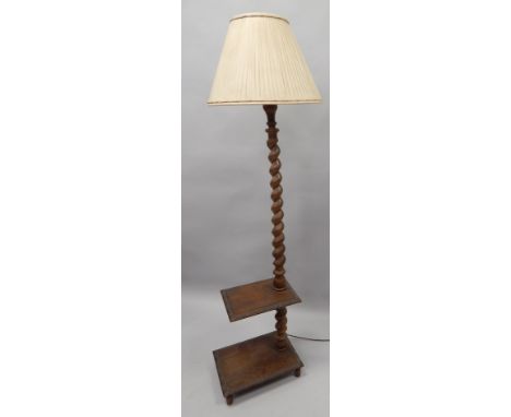 An early 20thC oak standard lamp, with spirally turned column, and two carved deer, on turned feet, with a shade, 182cm.