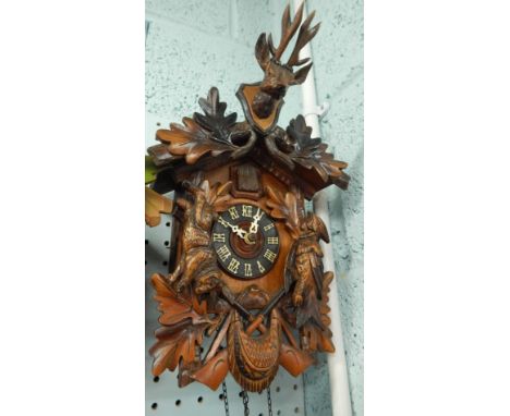 A Black Forest type cuckoo clock, mounted with a bird, a rabbit and a stags head