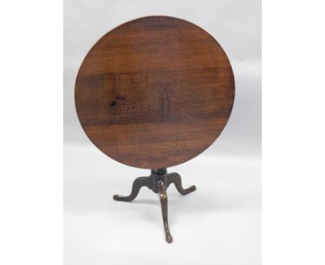An 19thC oak tilt top table, the circular top on a turned column and tripod base, 83.5cm diameter.