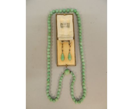 A jade necklace and earring set, to include a graduated carved jade necklace with leaf carved clasp silver plated, and a pair