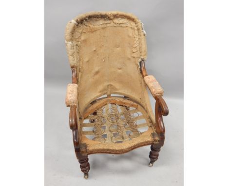 A Victorian mahogany open armchair, on turned legs with ceramic castors, frame striped and has undergone some restoration.