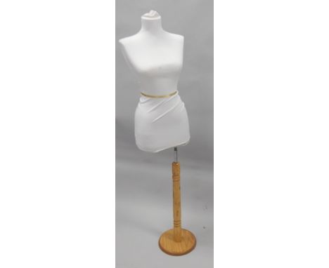 A modern mannequin, on a pine base.