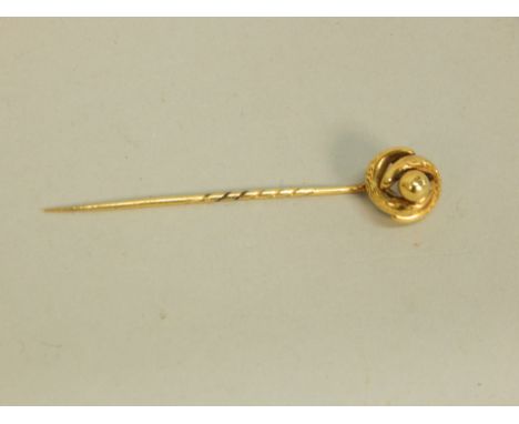 A stick pin, of twist and engraved design, yellow metal, unmarked, boxed. 